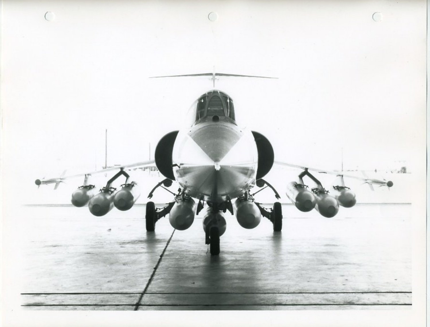 Frontansicht eines Lockheed-Starfighter-Mock-ups mit mehreren Bombenkörpern unter Flügeln und Rumpf sowie schlanken Lasten an den Flügelspitzen.
