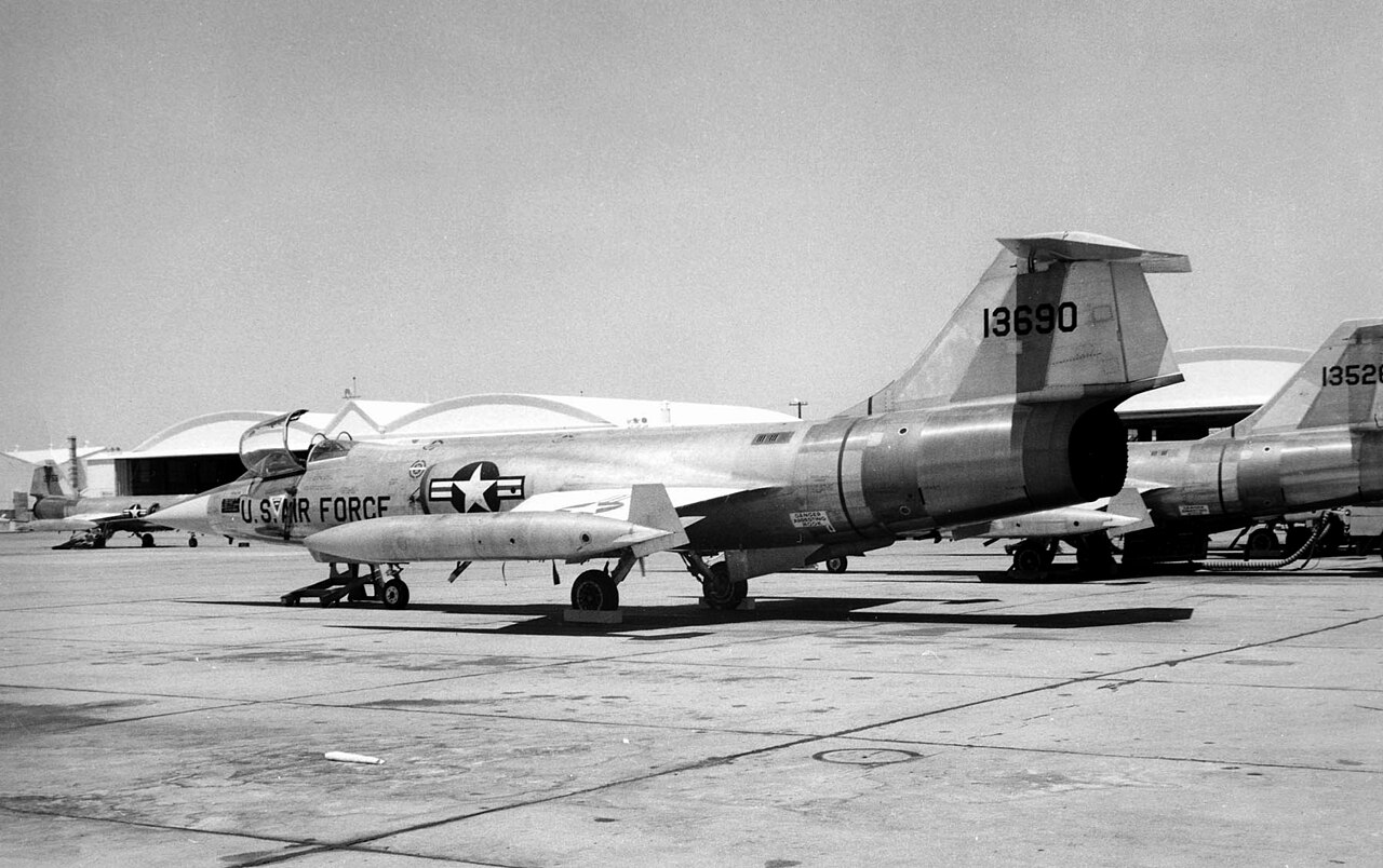 Schwarzweißaufnahme abgestellter deutscher F-104G in Luke mit US-Air-Force-Kennzeichen und Flügelspitzentanks.